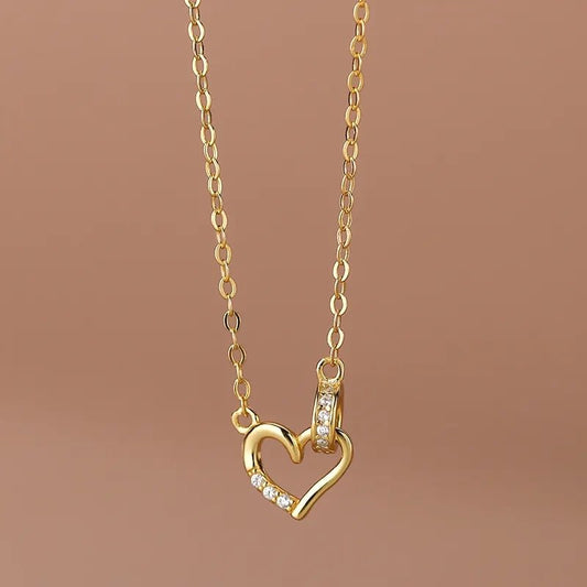Disfruta la elegancia de estajoya de plata18K bañada en oro de 925. Diseño de círculos entrelazados con corazón de zirconia blanca, ideal para un look con estilo. - Aurora Boré