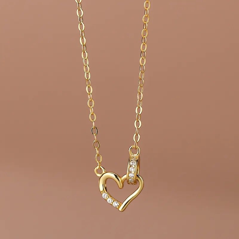Disfruta la elegancia de estajoya de plata18K bañada en oro de 925. Diseño de círculos entrelazados con corazón de zirconia blanca, ideal para un look con estilo. - Aurora Boré