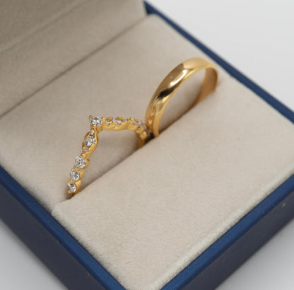 Dúo de anillos dorados: anillo V con zirconias brillantes y argolla clásica en oro 18K