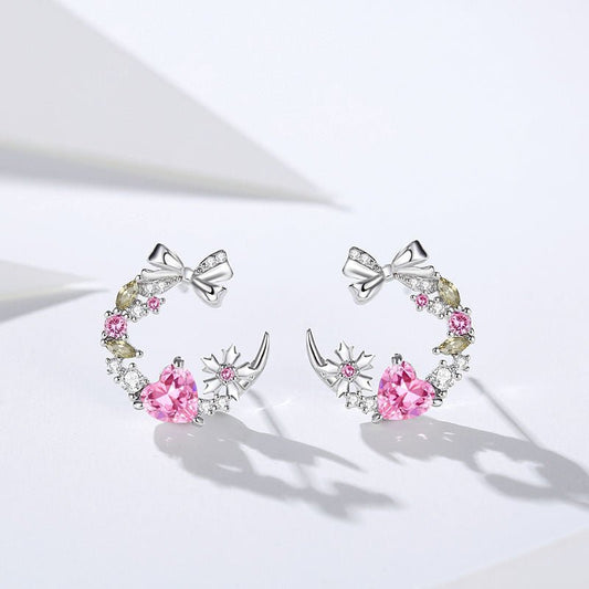 Hermosos aretes de corazón con circonitas rosadas brillantes.