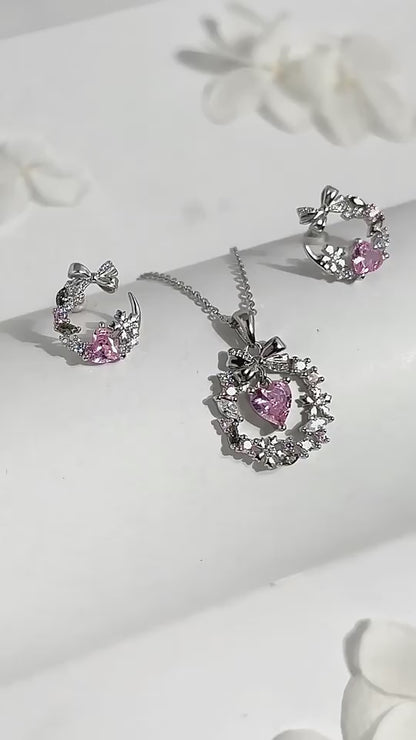 Conjunto de joyería con exquisito collar, fascinante dije y delicados aretes de corazón adornados con circonitas rosadas