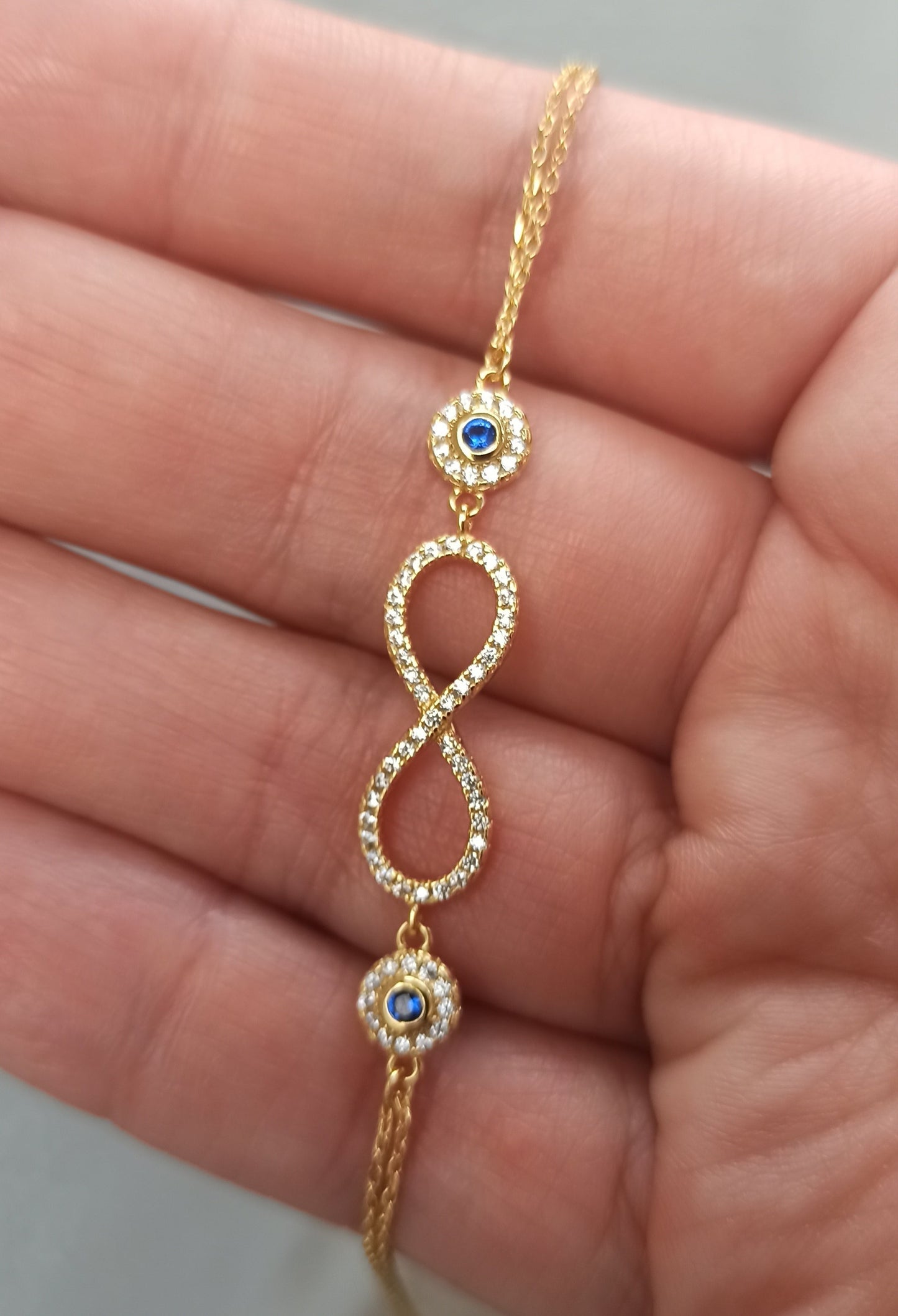 Pulsera de plata 925 con baño de oro 18K es una obra maestra. Infinito diseño y piedra azul. Un regalo único para la mujer moderna.